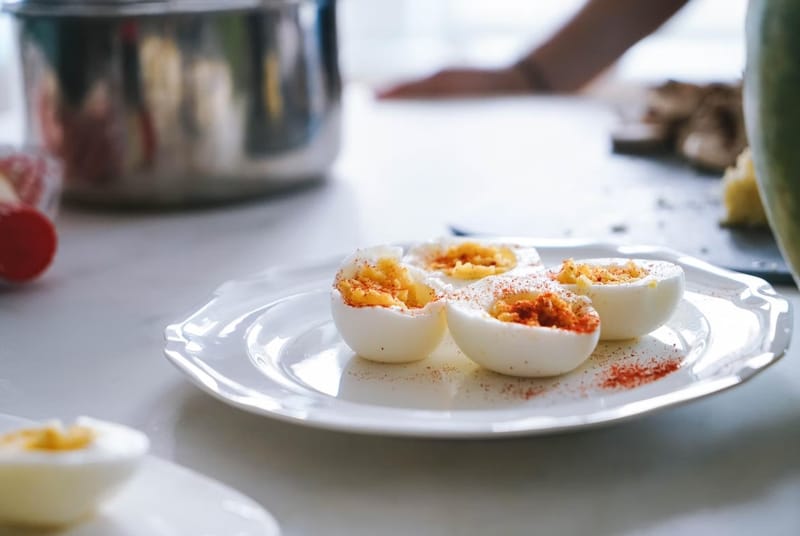 Exquisitos huevos rellenos con especias, en un plato blanco