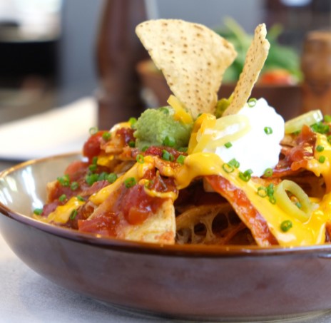 nachos caseros con salsa de queso y guacamole