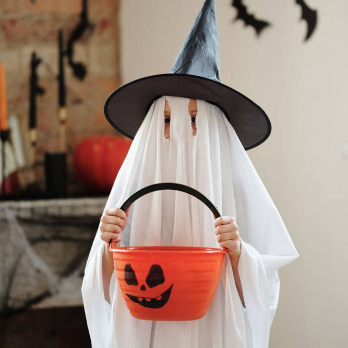 Niño con disfraz de fantasma y calabaza