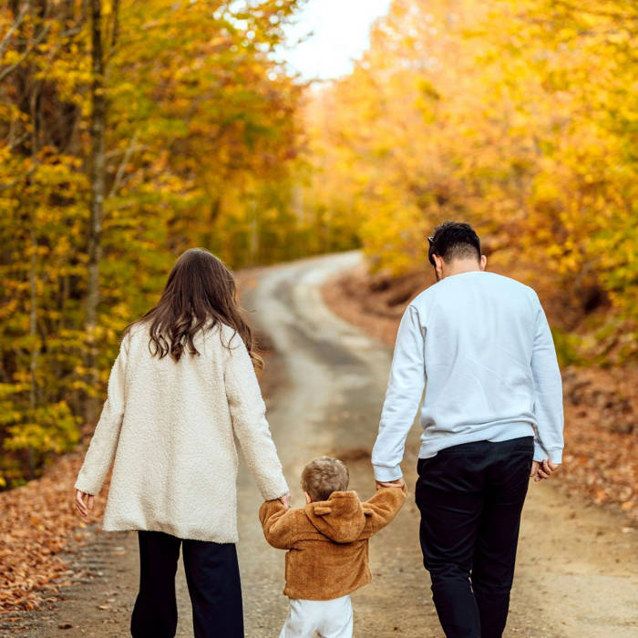 Escapadas en familia, otoño, turismo nacional, viajar con niños Familia paseando por un sendero en otoño